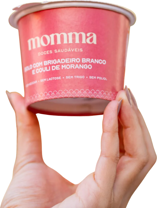 Mão segurando pote de bolo Momma de brigadeiro branco e coulis de morango
