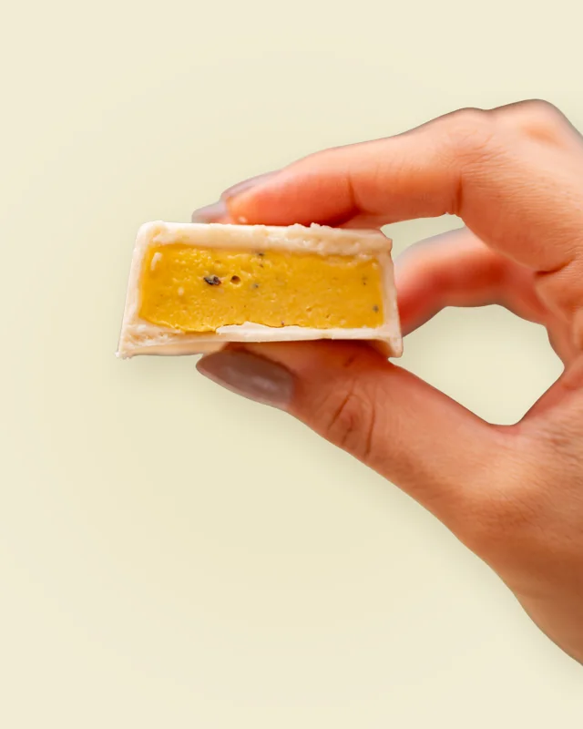 Mão segurando um mini de maracujá cortado ao meio