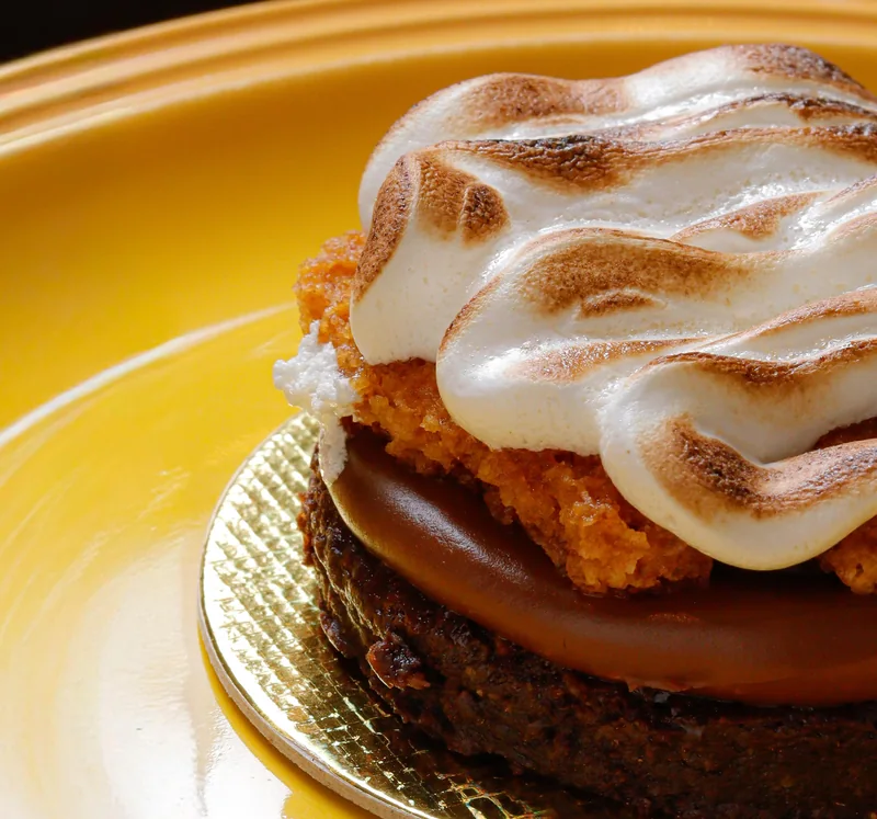 Torta Smores da Momma com merengue maçaricado em prato amarelo